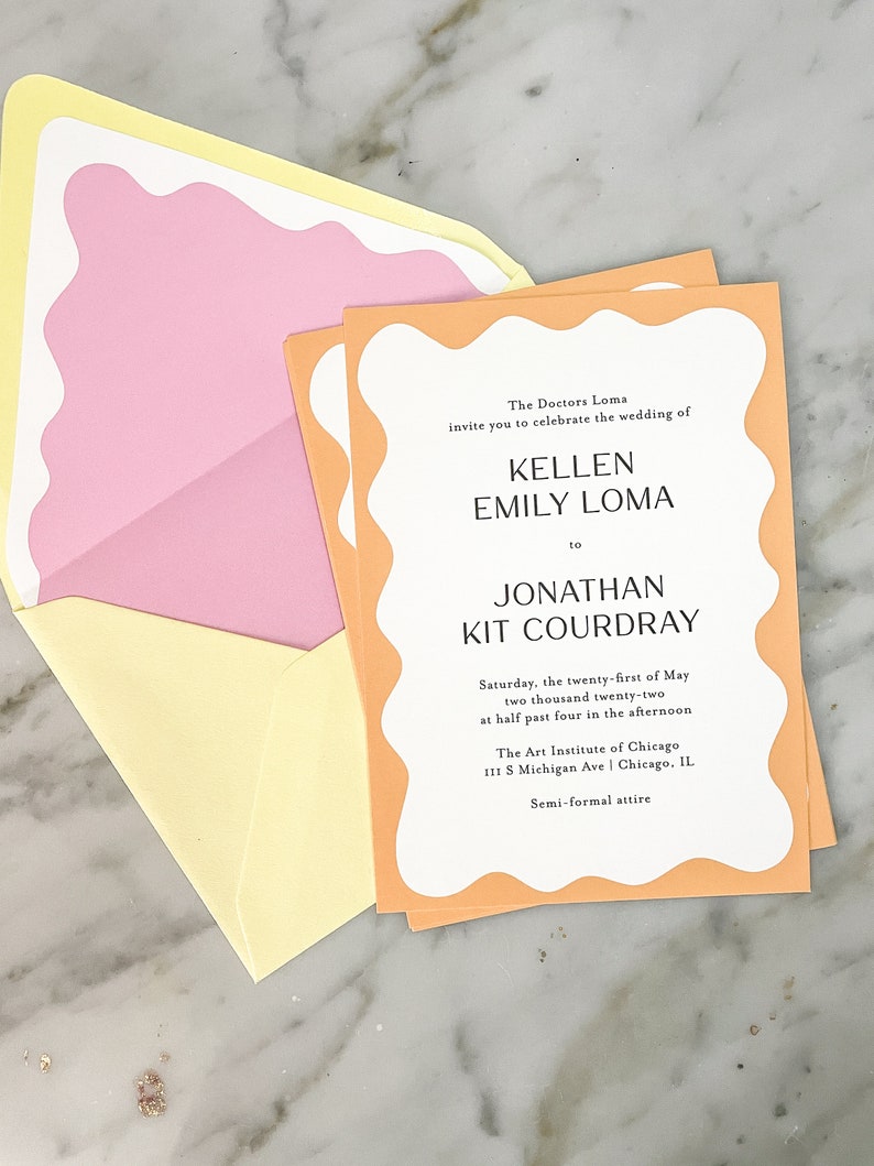 May include: A peach-colored wedding invitation with a white border and a wavy edge. The invitation announces the wedding of Kellen Emily Loma and Jonathan Kit Courdray on Saturday, May 21, 2022 at 4:30 PM at The Art Institute of Chicago. The dress code is semi-formal attire.