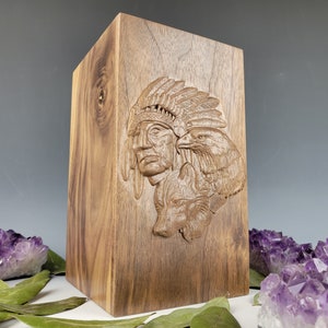 May include: A wooden box featuring a carved image of a Native American chief wearing a headdress and an eagle. The box is crafted from dark wood and has a natural finish.