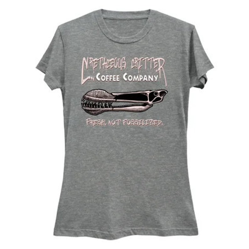 Puede incluir: Una camiseta gris jaspeada para mujer con un gr&aacute;fico de un molinillo de caf&eacute; y el texto "N'RTHEGUS GRITTER COFFEE COMPANY. FRESH, NOT FOSSILIZED."
