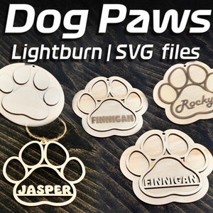 May include: Four wooden dog paw ornaments with names "Jasper", "Finnegan", "Finnegan" and "Rocky" engraved on them. The ornaments are designed for lightburn and SVG files.