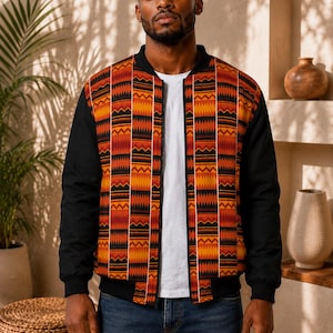 May include: A bomber jacket featuring a central panel with a vibrant orange, red, and black geometric pattern, contrasted by solid black sleeves and a black ribbed collar. The jacket has a full-length front zipper and is worn over a plain white t-shirt.