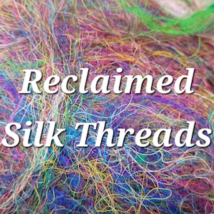 May include: A close-up of a pile of colourful reclaimed silk threads. The threads are a mix of blue, green, pink, yellow, and purple. Text on the image reads "Reclaimed Silk Threads."