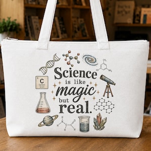 Puede incluir: Un bolso de tela blanco con un estampado gráfico que incluye el texto "Science is like magic but real." El diseño presenta ilustraciones de una cadena de ADN, un átomo de carbono, un telescopio, un planeta, un vaso de precipitados y estructuras químicas.