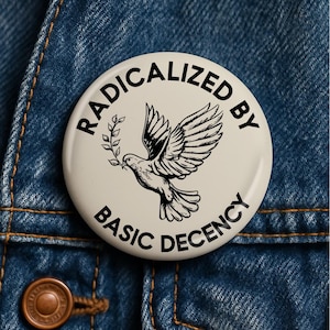 May include: A circular pinback button with a cream-colored background featuring a black line-art illustration of a dove carrying an olive branch. The text RADICALIZED BY BASIC DECENCY is printed in black capital letters around the dove.