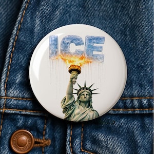 May include: A white button featuring the Statue of Liberty holding a torch with the word "ICE" in icy blue letters above. The torch flame is orange and yellow.