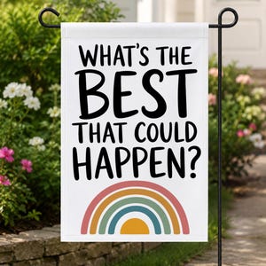 May include: A rectangular white garden flag featuring the black text "WHAT'S THE BEST THAT COULD HAPPEN?" printed in a bold, sans-serif font. Below the text is a semi-circular rainbow graphic composed of muted red, orange, teal, and yellow bands.