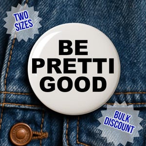 Puede incluir: Un botón blanco con el texto "BE PRETTI GOOD" en negrita negra. El botón está sobre un fondo de mezclilla azul. El texto adicional en la imagen incluye "TWO SIZES" y "BULK DISCOUNT".