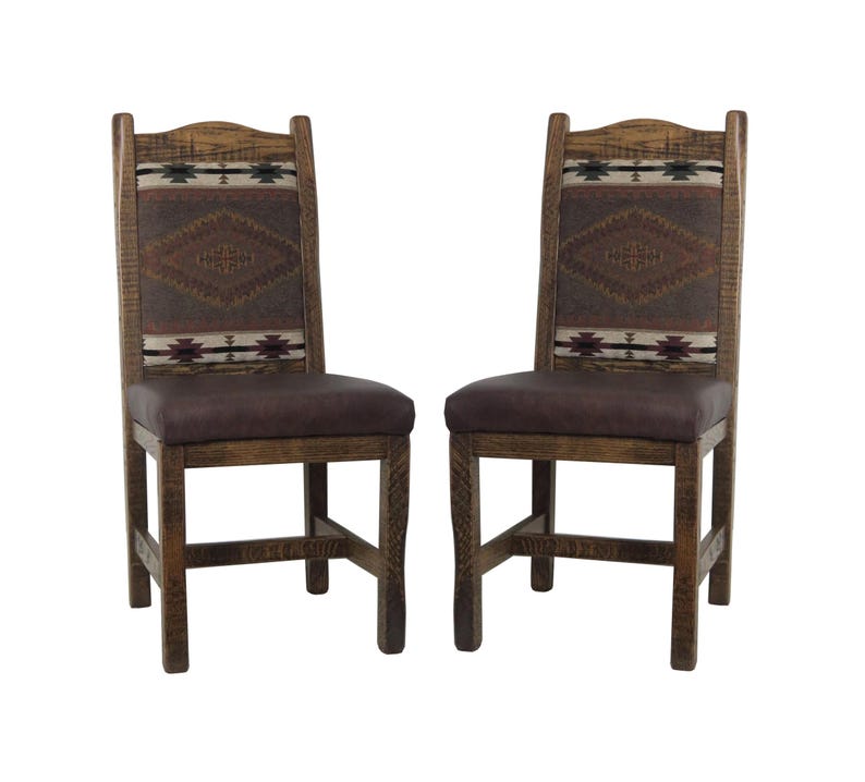 May include: Two wooden dining chairs with brown upholstery and a Southwestern-style patterned fabric backrest. The chairs have a rustic, distressed finish.