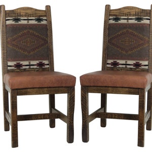 May include: Two wooden dining chairs with brown leather seats and patterned fabric backrests. The fabric features a southwestern design in shades of red, brown, and white.