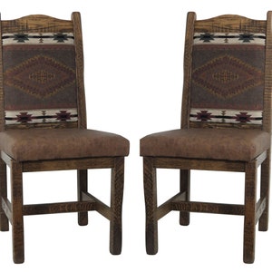 May include: Two wooden dining chairs with brown faux leather seats and woven patterned backs. The chairs have a rustic, Southwestern style.