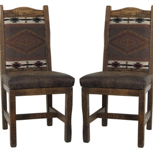 May include: Two wooden dining chairs with brown leather seats and patterned fabric backrests. The chairs have a rustic, Southwestern style.