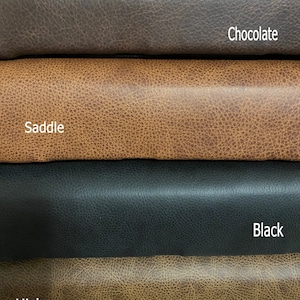 May include: Four stacked rolls of textured material in different colors. The top roll is dark brown labeled Chocolate, the second is tan labeled Saddle, the third is black labeled Black, and the bottom roll is light brown labeled Hickory.