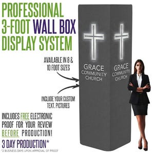 May include: A tall, rectangular, dark gray fabric display tower featuring a white cross graphic and the text "GRACE COMMUNITY CHURCH" on two visible sides. The display system is presented alongside text detailing its 3-foot width and 8 or 10-foot height options.