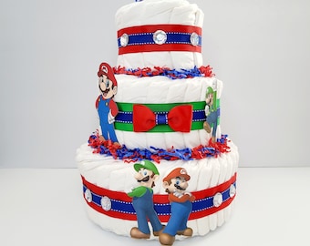 May include: A three-tier diaper cake decorated with red, blue, and green ribbon. The cake features characters from the Super Mario Bros. video game series, including Mario, Luigi, and a green turtle.