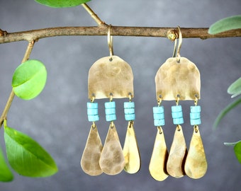 May include: A pair of gold-toned dangle earrings with turquoise beads and a hammered metal design.