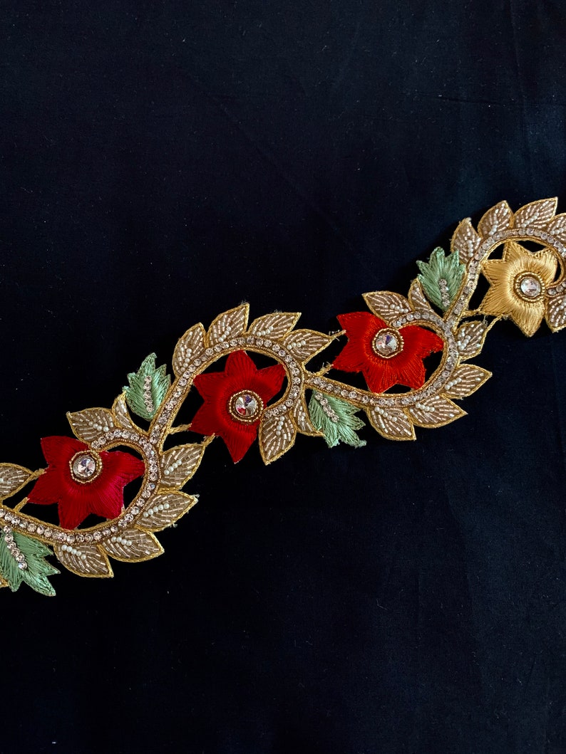 May include: Gold, red, and green embroidered trim with floral designs and rhinestones.