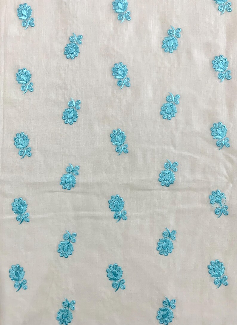 May include: White fabric with a repeating pattern of light blue embroidered flowers.