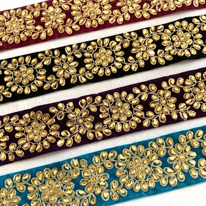 May include: Four velvet ribbon trims with gold embroidery and rhinestones. The trims are in burgundy, black, purple, and teal.