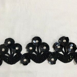 May include: Black beaded trim with a floral design. The trim features black sequins and small rhinestones.