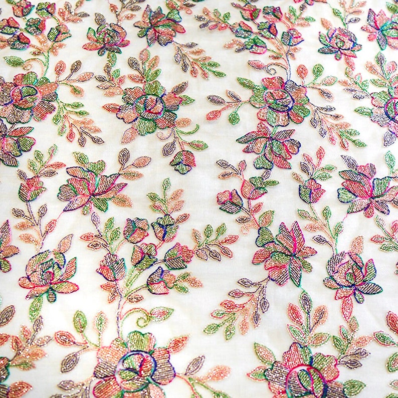 May include: White fabric with a floral pattern embroidered with iridescent beads in shades of pink, green, and blue.