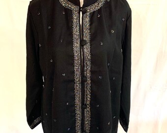 May include: A black beaded jacket with a mandarin collar and long sleeves. The jacket has a button closure and is decorated with gold and blue beads.