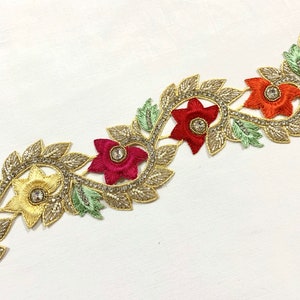 May include: Gold, red, and yellow floral trim with beaded accents. The trim features a repeating pattern of flowers and leaves.