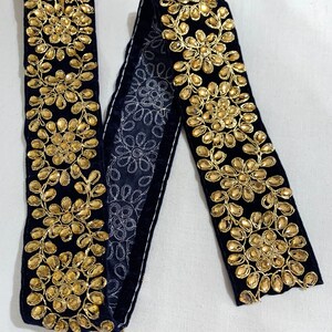 May include: Black velvet trim with gold embroidered floral designs and rhinestones.
