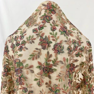 May include: Beige sheer fabric with embroidered floral pattern in shades of green, pink, and brown. The fabric is embellished with sequins and beads.