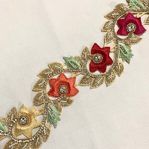 May include: Gold, red, and green embroidered trim with rhinestones and floral designs.