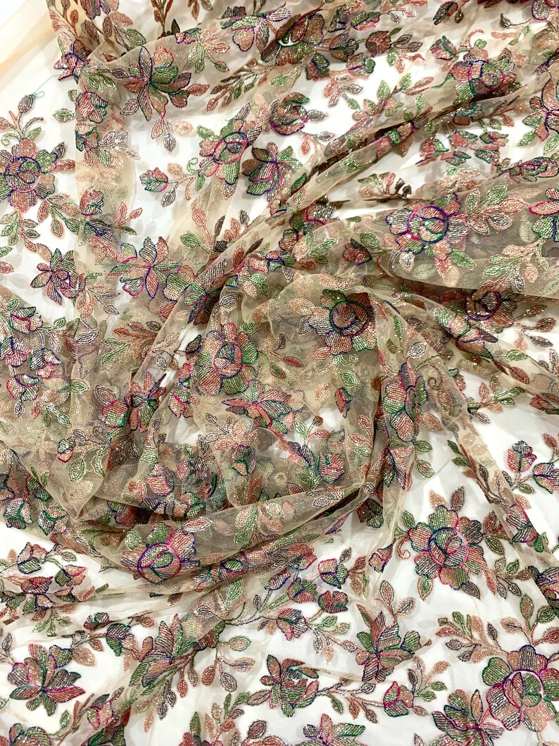 May include: Beige sheer fabric with embroidered floral pattern in shades of green, pink, and blue. The fabric is embellished with sequins and beads.