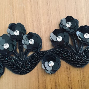 May include: Black beaded trim with black sequin flowers and clear rhinestones. The trim is perfect for adding a touch of elegance to any project.