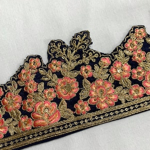 May include: A navy blue trim with gold and pink floral embroidery. The trim has a scalloped edge and a row of gold sequins along the bottom.