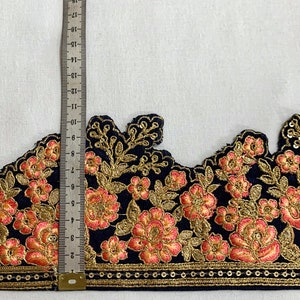 May include: Black velvet trim with gold and peach embroidery. The trim features a scalloped edge and a row of gold sequins.