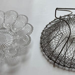 May include: Two different serving dishes. One is a clear glass dish with a scalloped edge and a center design. The other is a silver wire mesh dish with a handle.