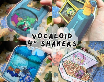 Puede incluir: Cuatro colgantes shaker Vocaloid transparentes de 10 cm, con Hatsune Miku, Kagamine Twins, Kaito y Megurine Luka. Cada colgante tiene un diseño único con colores vibrantes e ilustraciones de personajes. El texto "VOCALOID 4" SHAKERS" se muestra.
