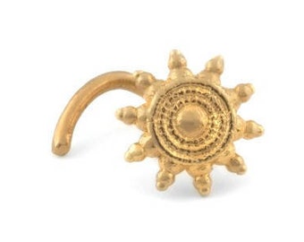 May include: Gold nose ring with a sun design. The sun has a circular center with concentric circles and a ring of points around the edge.