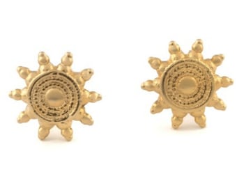 May include: A pair of gold-toned sun-shaped earrings with a textured design.