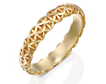 May include: A gold band ring with a geometric pattern. The ring is made of a smooth, polished metal and has a delicate, intricate design.