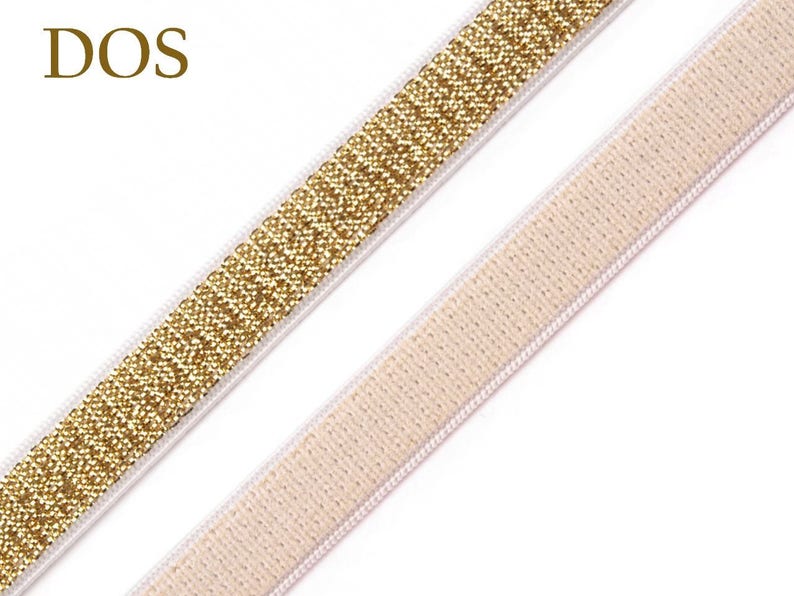 May include: Close-up of two decorative ribbons. One ribbon is gold with a glittery texture, and the other is a light beige color. Both ribbons have a white border. The word "DOS" is in the upper left corner.