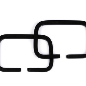 Può includere: Tre anelli di plastica nera, intrecciati, formando un design a catena.