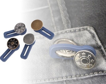 May include: Four silver and bronze snap buttons with blue plastic clasps. The buttons have a star design. One button is shown attached to a pair of blue jeans.