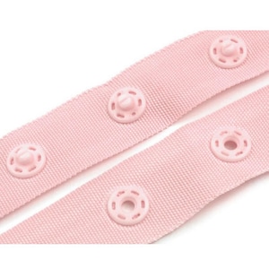 Puede incluir: Primer plano de dos tiras de tela rosa claro con broches rosas a juego y espaciados uniformemente. La tela tiene un tejido texturizado, y los broches son circulares con un bot&oacute;n central.