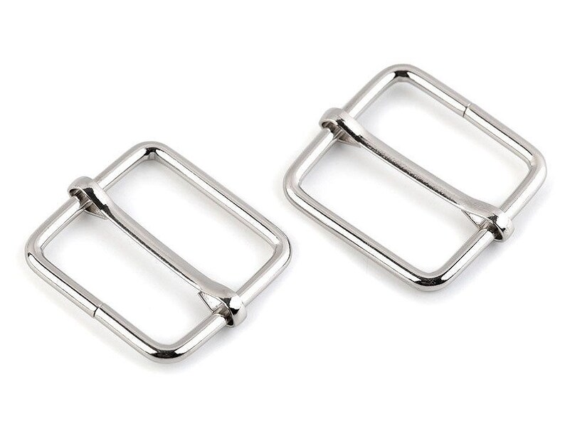 May include: Two silver metal buckle closures for straps or belts. The buckles are rectangular with a smooth finish.