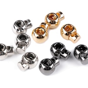 Può includere: Un set di sei chiusure a scatto in metallo, in finiture argento, oro e nero. Le chiusure sono rotonde e hanno un meccanismo a molla.