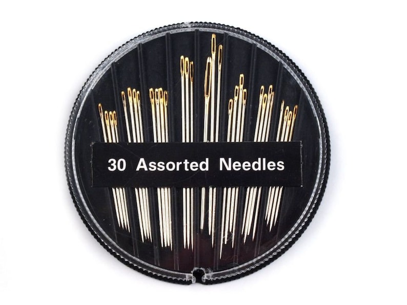 May include: A round, black plastic container with a clear lid filled with 30 assorted needles. The container has a white label that reads "30 Assorted Needles".