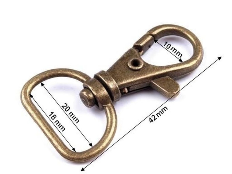 May include: A gold-toned metal swivel clasp with a D-ring. The clasp measures 42 mm long, 10 mm wide, and the D-ring measures 20 mm long and 18 mm wide.