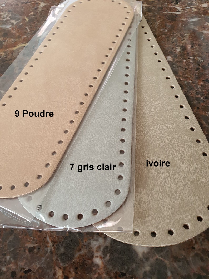 May include: Three leather pieces for crafting, in beige, light gray, and ivory. The beige piece is labeled "9 Poudre", the light gray piece is labeled "7 gris clair", and the ivory piece is labeled "ivoire".