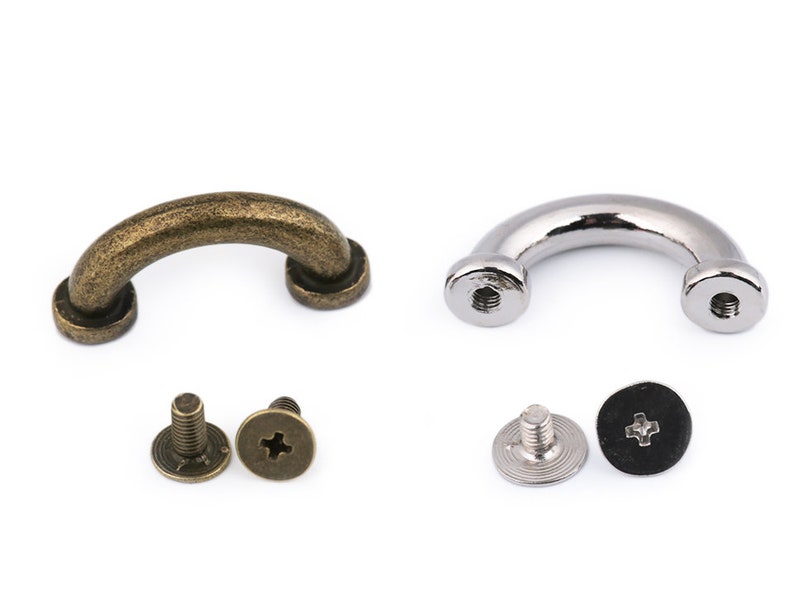 May include: Two sets of metal D-ring handles with screws. One set is antique brass and the other is silver. Each set includes two screws and a washer.