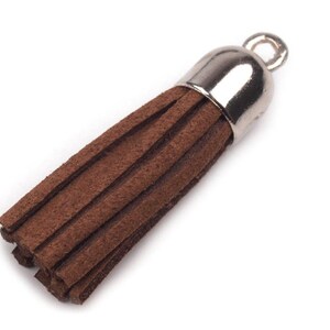 May include: A brown suede tassel with a silver metal top and a loop for attaching to a key chain or other item.