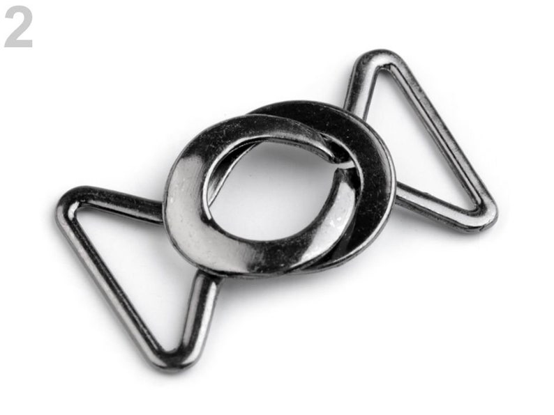 May include: A silver metal slider buckle with two triangular loops. The buckle is designed to be used for adjusting the length of straps or belts.